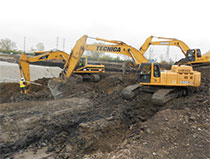 Excavators work in tandem to remove contaminated soil.