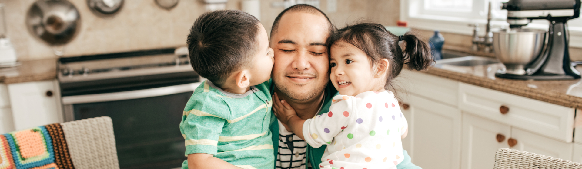 father hugging children